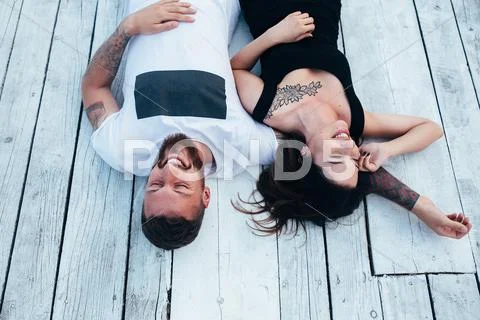 Man and woman lie on the wooden floor Stock Photos