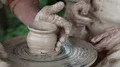 Man and woman makes a pot on pottery wheel HD Footage