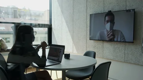 Man and woman in masks making a long distance hiring video call in office Stock Footage