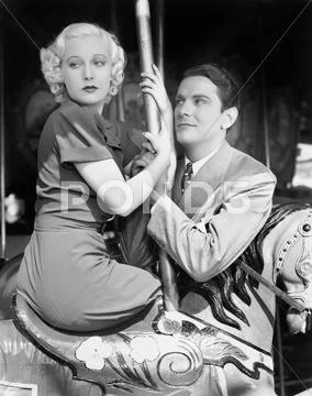 Man and woman on a merry-go-round Stock Photos