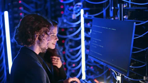 A man and a woman programming in a server room Stock Footage 287375416