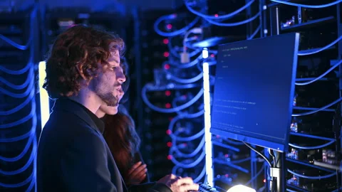 A man and a woman programming in a server room Stock Footage 287430138