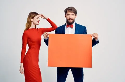 Man and woman pull at each other red mockup poster advertisement sale Stock Photos
