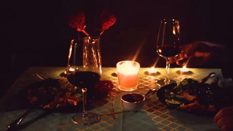A man and a woman at a romantic dinner. Drink wine and eat by candlelight. Stockbeeldmateriaal 102114553