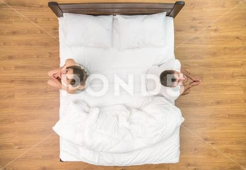 The man and woman sit on the bed. view from above Stock Photos