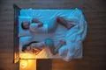 The man and woman sleeping on the bed. evening night time. view from above Photo