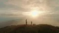 The man and woman standing on the beautiful mountain on the sunset background 4k or 4k+ Resolution