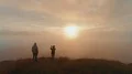 The man and woman standing on a beautiful mountain on the sunset background 4k or 4k+ Resolution