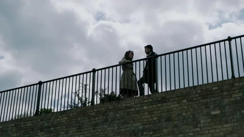 Man and woman standing  behind fence and talking Video stock 130599853