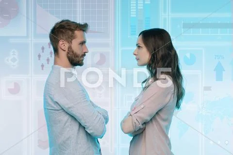 Man And Woman Standing Face To Face, Data On Graphical Screen Behind Them