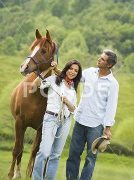 Man and a woman standing with a horse Stock Photos