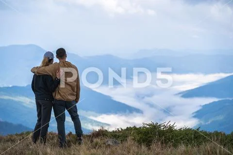 The man and a woman standing on the mountain landscape background Stock Photos
