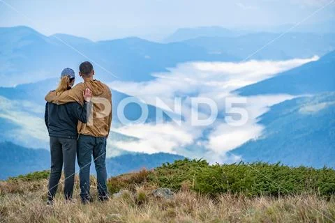 The man and a woman standing on the mountain landscape background Stock Photos