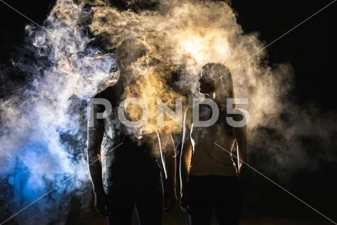 The man and woman standing near the smoke in the dark Stock Photos