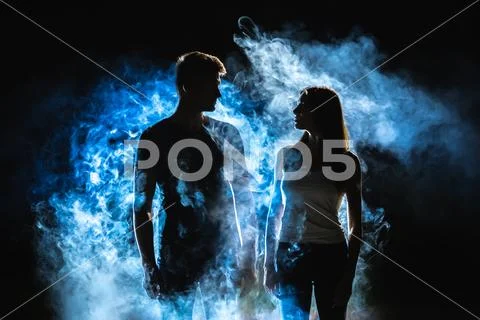 The man and woman standing near the smoke in the dark Stock Photos