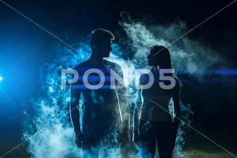 The man and woman standing in the smoke on a bright light background Stock Photos