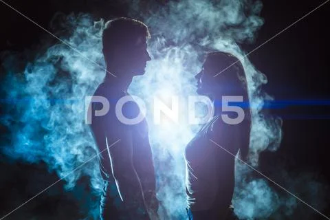 The man and woman standing in the smoke on a bright light background Stock Photos