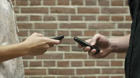 Man and woman using cell phones to share files Stock Footage 8320152
