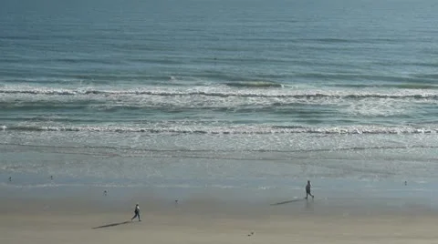 Man and woman walking on beach Stock Footage
