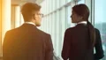The man and a woman walking near windows in the office center. slow motion HD Footage