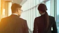 The man and a woman walking near windows in the office center. slow motion 4k or 4k+ Resolution