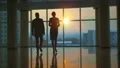The man and woman walking in the office hall on a sunset background. slow motion HD Footage