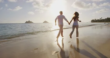 Man and woman, young people on tropical beach running having fun Stock Footage