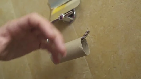 Man is angry at an empty roll of toilet paper - throws it Stock Footage 82312249