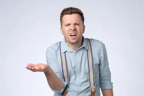 Man with angry facial expression asking so what do you want from me. Stock Photos