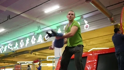 Man animator entertains children in trampoline park throw little girl in foam Stock Footage