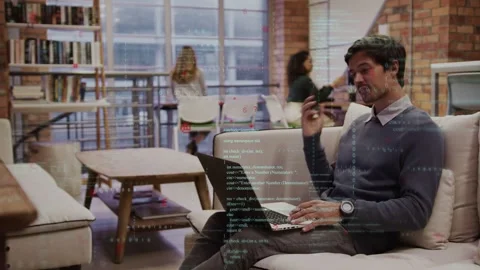 Man answering call while typing laptop in tech space, code overlays syncing with Stock Footage 335282055