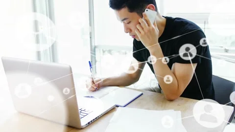 Man answering phone, writing notes at desk, animated icons appearing across Stock Footage 330258791