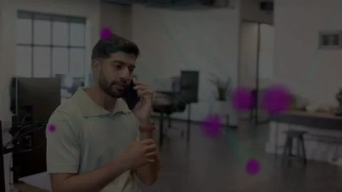 Man answering ringing phone at desk, gesturing as purple circles crossing Stock Footage 331757699