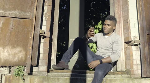 Man Answers A Phone Call And Laughs, While Hanging Out And Relaxing In Park Stock Footage