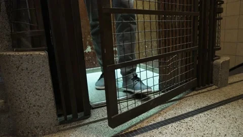 Man in antique elevator descending and arriving at the floor of a Stock Footage 160099249