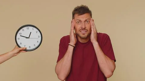 Man with anxiety checking time on clock, running late to work, being in delay Stock Photos