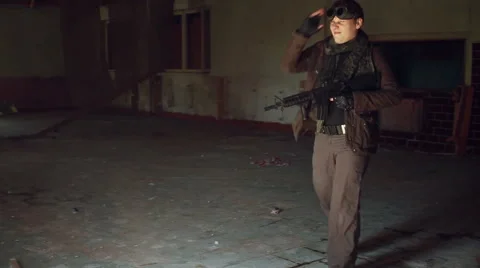 Man in apocalyptic clothing and a automatic in his hands enters an abandoned Stock Footage 67993577