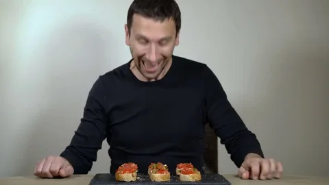 The man with an appetite eats bruschetta Stock Footage 73923320