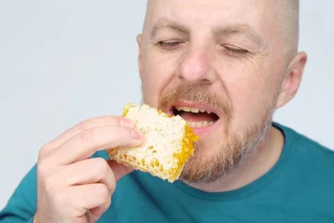 The man is appetizing eats honey. healthy and proper nutrition. Stock Photos
