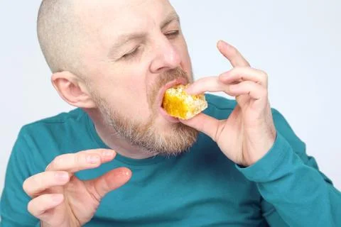 The man is appetizing eats honey. healthy and proper nutrition. Stock Photos