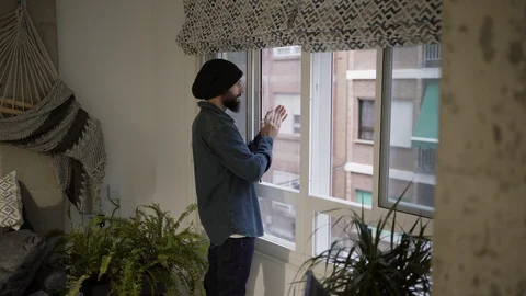 Man applauding from his window in solidarity with those who work in the pandemic Stock Footage 129103017