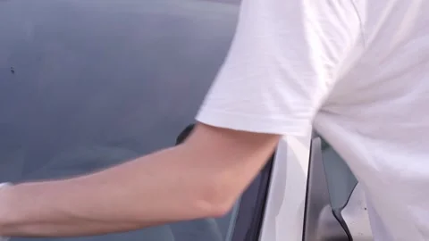 A man applies a anti-rain coating to the windows and headlights of a car. Stock Footage 337907133