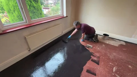 Man applies damp proof membrane coating to house floor Stock Footage 292999816