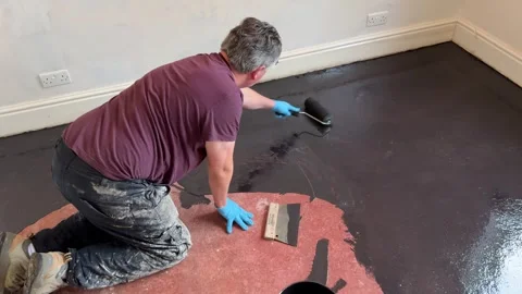 Man applies damp proof membrane coating to house floor Stock Footage 293000140