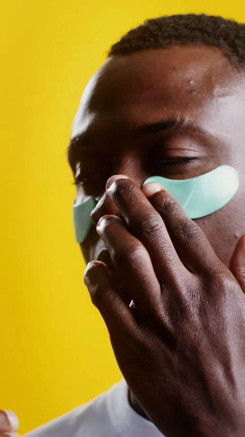 A man applies moisturizing patches under his eyes - Care. Stock Footage 323939852