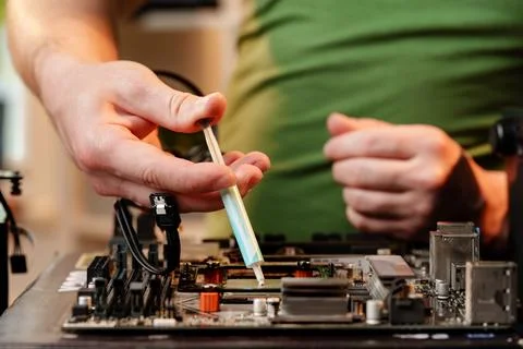 Man applies thermal paste to the CPU 库存照片