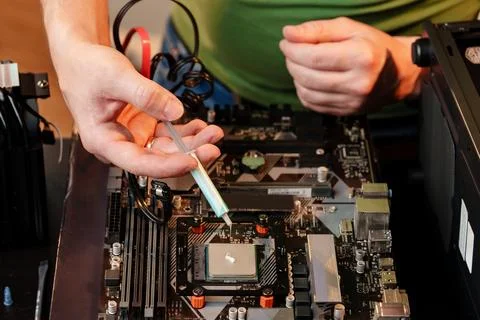 Man applies thermal paste to the CPU 스톡 사진