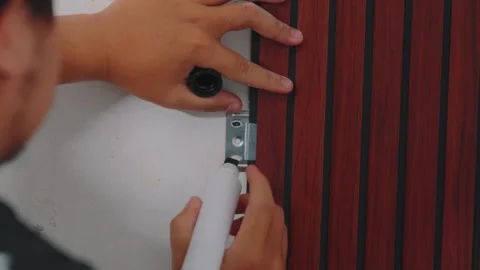 Man Applying Adhesive to Door Hinge During Installation Process Stock Footage 333322001
