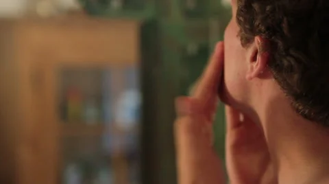 Man applying after shave in front of the mirror Stock Footage 40843640