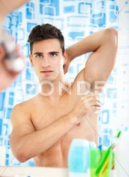 Man applying antiperspirant Stock Photos